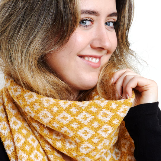 Lovely knitted scarf using luxurious Italian yarn, this 2 colour jacquard pattern scarf is beautifully soft and sumptuous to wear.  The geometric pattern  "Carsphairn" is just the right scale for a scarf and easy to wear. Colour Amber.